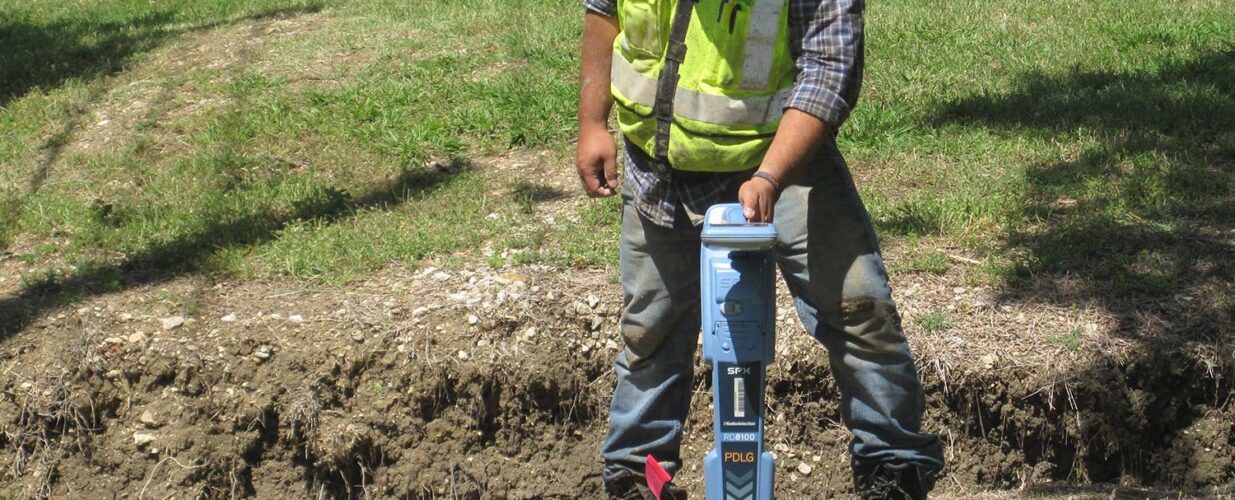 SUE crew member working on land development with tool in ground